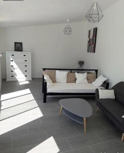 un salon avec un canapé et une table dans l'établissement Location vacances T1 indépendant avec piscine privée, à Saint-Mitre-les-Remparts