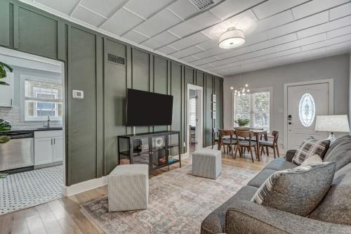 a living room with a couch and a flat screen tv at Neighborly Heights - Downtown King BBQ Fire Pit in Colorado Springs