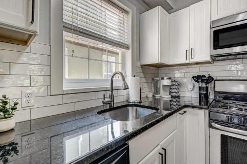 a kitchen with white cabinets and a sink at Neighborly Heights - Downtown King BBQ Fire Pit in Colorado Springs