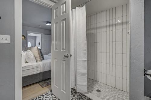 a room with a bed and a door with a bathroom at Neighborly Heights - Downtown King BBQ Fire Pit in Colorado Springs