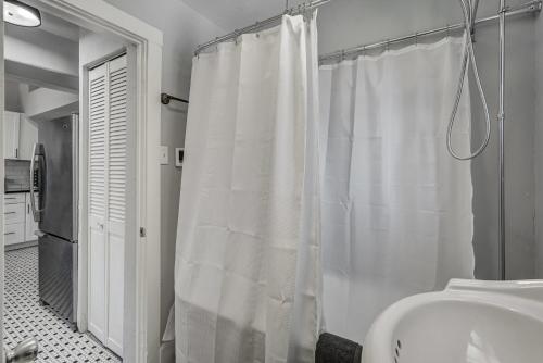 a white shower curtain in a bathroom with a sink at Neighborly Heights - Downtown King BBQ Fire Pit in Colorado Springs