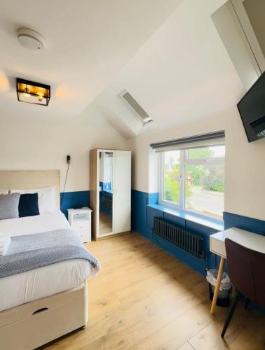 a bedroom with a bed and a desk and a window at Sun Guest House Cambridge in Cambridge