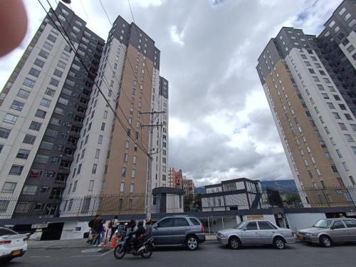 a group of people standing in a parking lot with buildings at Cómodo apartamento central in Pasto