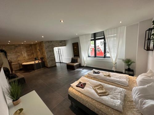 Habitación grande con 2 camas y bañera. en Suite Julius Cesar, en Berlín