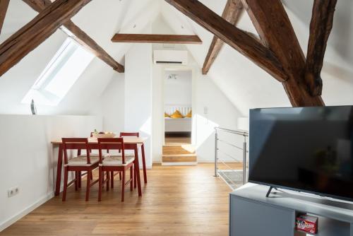 a living room with a dining room table and a tv at Ferienwohnung Loblocher Mühle in Neustadt an der Weinstraße