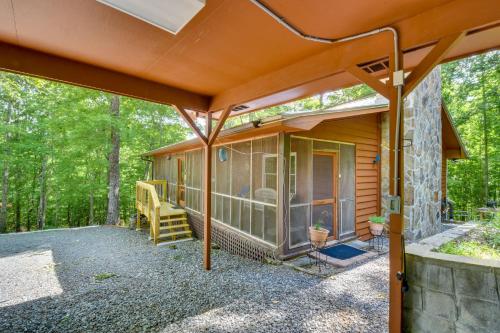 a screened in porch of a cabin in the woods at Cozy Hiawassee Cabin - 4 Mi to Lake Chatuge! in Hiawassee