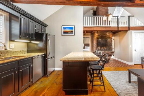 a kitchen with a counter and a bar with stools at Essex Street Inn & Suites, an Ascend Collection Hotel in Newburyport