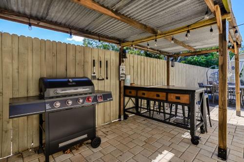 a backyard patio with a grill and a table at Pool Home Close to the Beach and Downtown in Seminole
