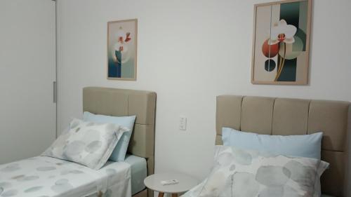 een slaapkamer met een bed en 2 kussens bij RED DESIGN - Apto completo 2 Qts 901 in Vitória