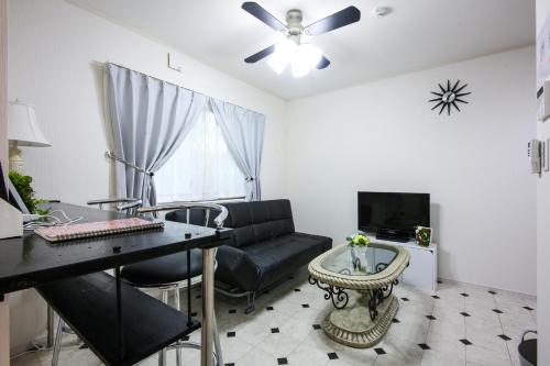 a living room with a black couch and a table at 3, Kameido, Entire house for rent, 亀戸 in Tokyo