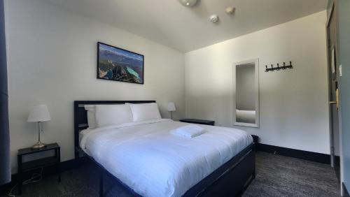 a bedroom with a large bed with white sheets at HI Lake Louise Alpine Centre - Hostel in Lake Louise