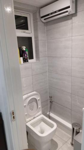 a white bathroom with a toilet and a sink at Luxurious & Stylish Flat, Access to Public Transport & Shops in Thamesmead