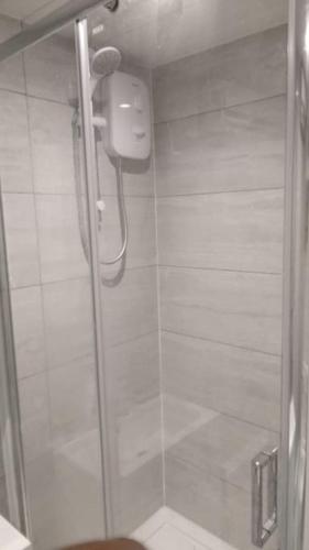a shower with a glass door in a bathroom at Luxurious & Stylish Flat, Access to Public Transport & Shops in Thamesmead