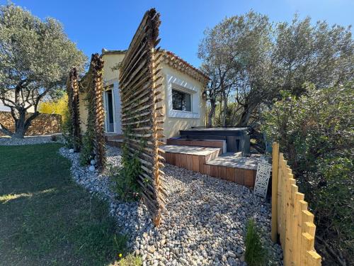 a house with a brick wall next to a yard at Lodge Paradisiaque Spa in Cazouls-lès-Béziers