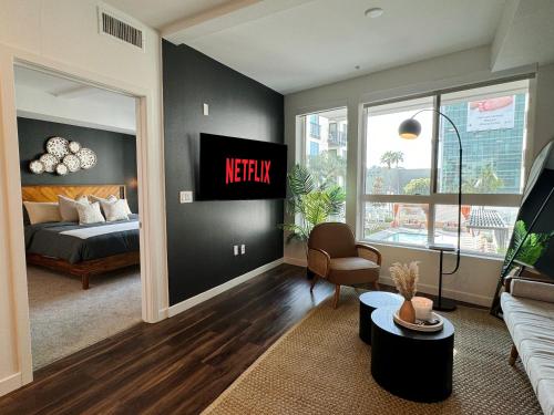 a living room with a bed and a tv on a wall at Spacious Hollywood Home Sunset View-Free Parking 10mins to Universal Studios in Los Angeles