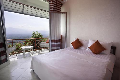 a bedroom with a white bed and a balcony at RedHill Kandy in Kandy