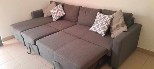 a brown couch in a living room with pillows on it at Zellys bk in Praia