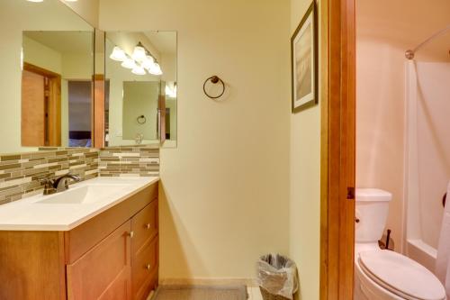 a bathroom with a sink and a toilet and a mirror at Bigfork Condo with Hot Tub Access, By Lake! in Bigfork