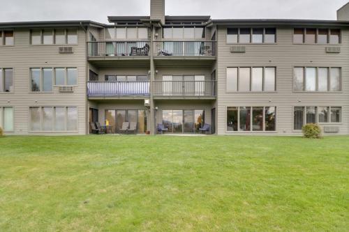 an apartment building with a lawn in front of it at Bigfork Condo with Hot Tub Access, By Lake! in Bigfork