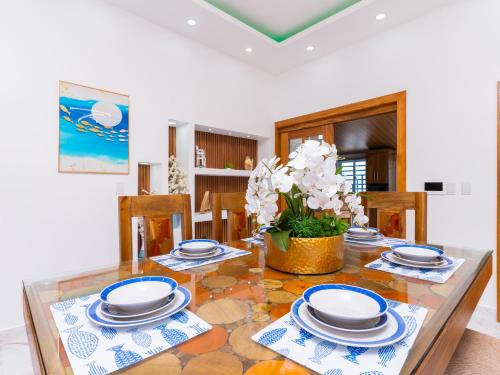 a dining room with a glass table with plates at Villa doña kika in San Felipe de Puerto Plata