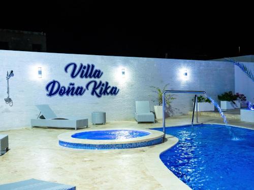 a swimming pool with a sign on the side of a building at Villa doña kika in San Felipe de Puerto Plata
