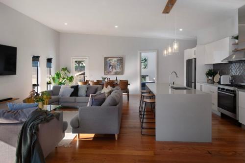 a kitchen and living room with a couch and a table at Away - 4 bedroom 2 bathroom family home in Daylesford