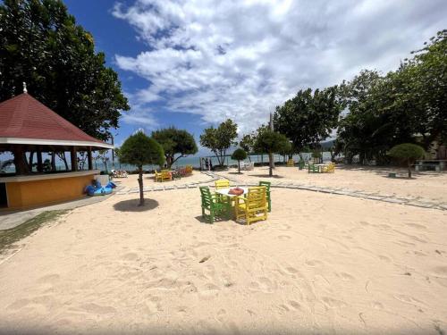 a beach with chairs and tables in the sand at Avant Dream Escape in Richmond