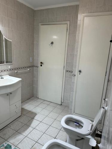 a white bathroom with a toilet and a sink at LPR Express in Monte Grande