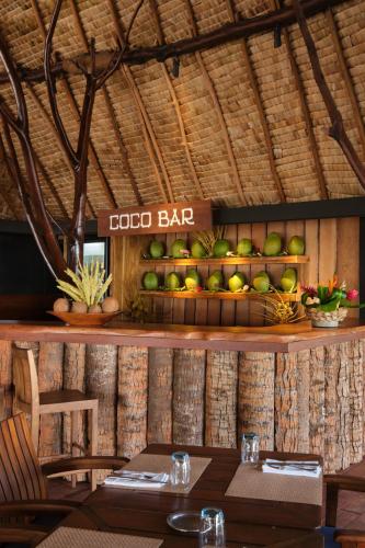 a restaurant with a table and a sign that reads food bar at Le Taha'a by Pearl Resorts in Motu Tautau