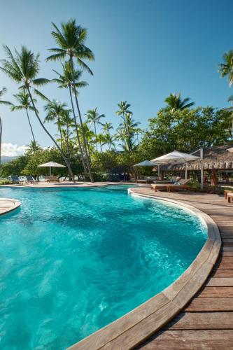 a swimming pool at a resort with palm trees at Le Taha'a by Pearl Resorts in Motu Tautau