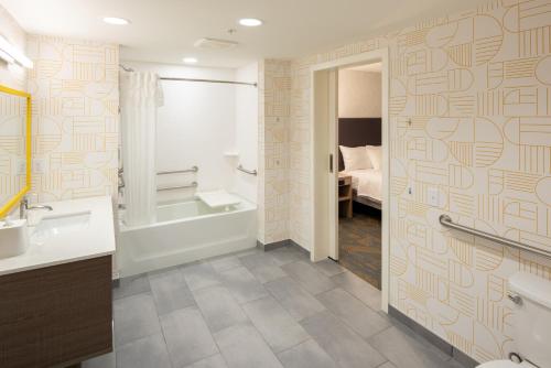 uma casa de banho com uma banheira, um lavatório e um WC. em Home2 Suites By Hilton East Haven New Haven em East Haven