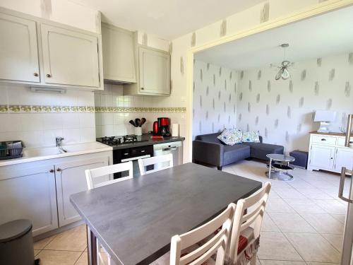 une cuisine et un salon avec une table et des chaises dans l'établissement Gîte charmant à Naives-Rosières : 4 pers., grand terrain fleuri, proche Bar-le-Duc - FR-1-585-51, à Rosières-devant-Bar