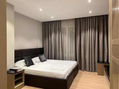 a bedroom with a large bed in a room at Coastline Luxury Apart Hotel in Golem