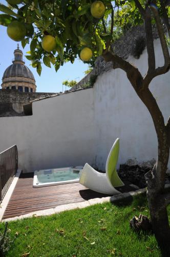 a bath tub sitting on a deck next to a tree at Iblainsuite in Ragusa