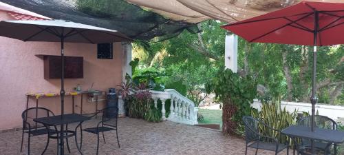 two tables and chairs with umbrellas on a patio at Villa lirios in Valladolid