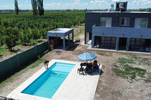 a man standing next to a swimming pool next to a house at Casa La Olguita in Vista Flores