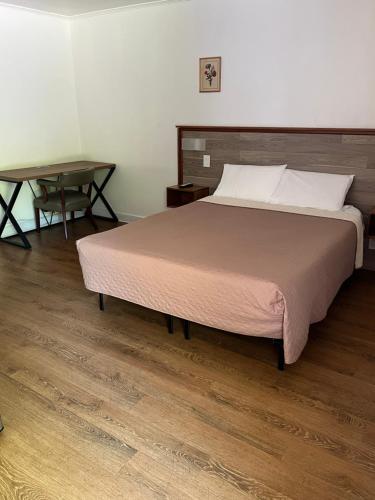 - une chambre avec un grand lit et une table dans l'établissement Cadet Motel, à Cornwall-on-Hudson