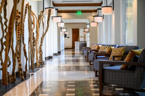 a hallway with couches and chairs in a building at Real Intercontinental Metrocentro Managua by IHG in Managua