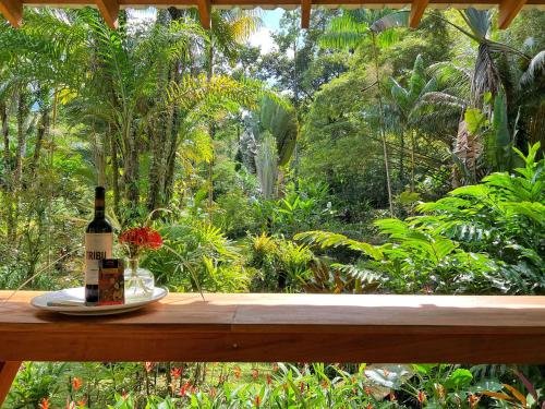 a bottle of wine and flowers on a wooden table at Geckoes Lodge in Cocles