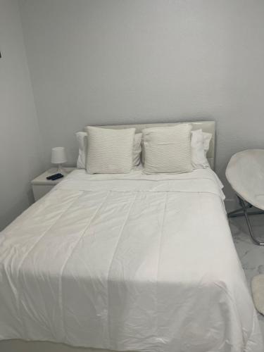 a white bed with white sheets and pillows at Elegant studio in Tamiami