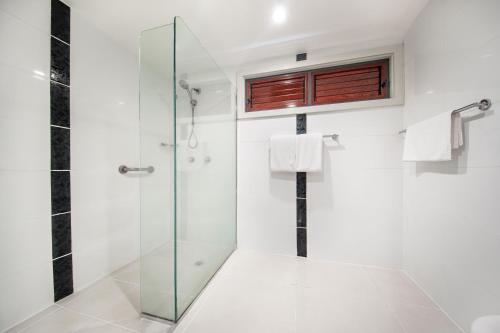 W łazience znajduje się prysznic i przeszklona kabina prysznicowa. w obiekcie Tanoa Tusitala Hotel w mieście Apia