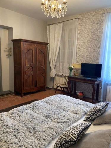 a bedroom with a bed and a desk with a laptop at Chez Les Brocs B&B in Canet d'Aude
