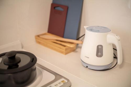 a electric kettle sitting on a counter next to a stove at Rakuyado Shinimamiya in Osaka