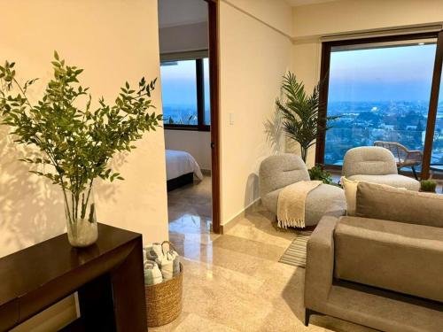 a living room with a couch and a chair at Increíble Vista con 3albercas-Gym-ludoteca in Conchal