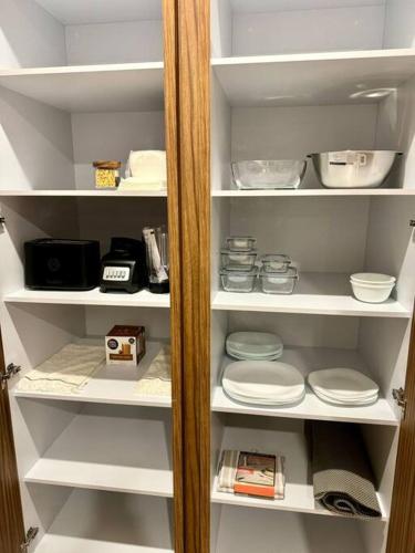 a white pantry with white plates and bowls at Increíble Vista con 3albercas-Gym-ludoteca in Conchal