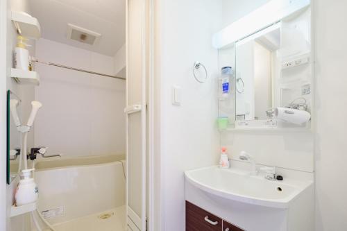 a white bathroom with a sink and a mirror at AMs海峯楼307 in Otaru