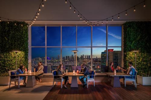 a group of people sitting at tables in a room with a view at Marriott Executive Apartments Downtown, Abu Dhabi in Abu Dhabi