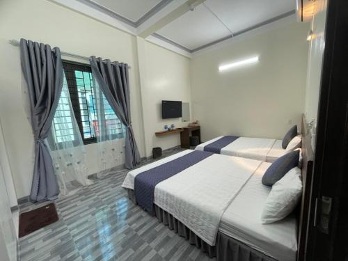 una habitación de hotel con una cama y un televisor en MINH HUY HOUSE Mộc Châu, en Mộc Châu