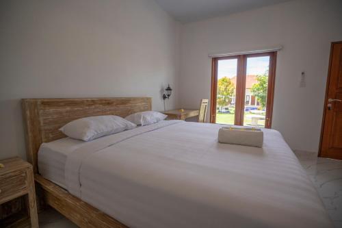a bedroom with a large white bed and a window at The Uma Canggu in Canggu