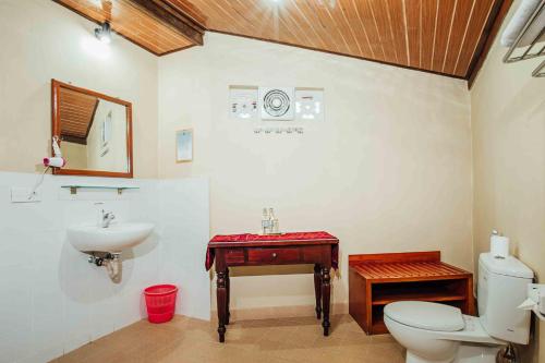 a bathroom with a sink and a toilet and a sink at Kuta Puri Bungalows, Villas and Resort in Kuta